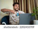 Small photo of Man cutting up his credit card. Indebted man cutting credit card. Desperate man. Man cutting his credit card with scissors. Concept photo.