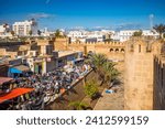 Small photo of Sousse Tunisia - Dec 20 2024: Looking down on a traditional open air clothing market nestling next to the Ribat and the ancient medina walls in Sousse, Tunisia.