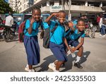 Small photo of Dar es Salaam Tanzania - Jan 26 2024: A young girl and two young boys in school uniform on their way home from school in Dar es Salaam, Tanzania
