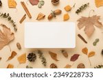 Greeting card mockup with autumn leaves on color background, top view