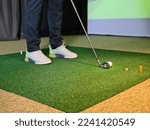 Small photo of Professional male golfer playing golf indoors in golf simulator closeup. training field with screen