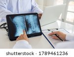 doctor diagnose spine lumber vertebrae x-ray image on digital tablet for diagnose Herniated disc disease with radiologic technologist team.