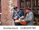 Small photo of Dudley, West Midlands-united kingdom July 13 2019 RAF airman buying black market goods from a male street seller 1940's war time ration concept