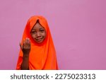 Small photo of portrait of an african muslim young girl smiling and overexcited, small girl gesturing with her hand