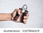 Hand of Southeast asian, Chinese man gripping hand exercise gripper.