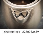 An electric kettle with limescale. In hard water area, region. Top view. Selective focus. Close up of the teapot spout with traces of limescale