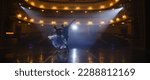 Small photo of Couple of classical ballet dancers practice on theatre stage before performance. Man in training suit lifts graceful ballerina. Dance choreography rehearsal. Illuminated theatrical hall