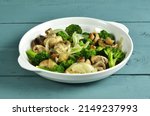 Tumis brokoli jamur. Mushroom broccoli stir fry is a dish consisting of broccoli, tofu and mushrooms, cooked by sauteing. Served on a plate. Selective focus