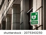 Small photo of Electric defibrillator logo on a sign in an urban environment, abiding by European standards, indicating the nearby presence of AED device, an obligation to deal with cardiac diseases and heart attack