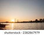 Small photo of Panorama of the reka Sava river in belgrade, in Serbia, with a Industrial landscape of Eastern Europe with red and white factories and chimneys polluting, at dusk, during a sunny afternoon.