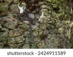 Small photo of Twisted iron cross in the knave of a ruined chapel.