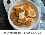 Small photo of Pancakes cereal, tiny thin funny crumpet, children's food. Breakfast with drink, dark table, bright morning, top view