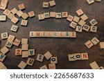 Interest spelled with Scrabble tiles on a brown wooden table alphabets scattered. High quality photo