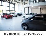 Car dealership showroom interior with brand new vehicles for sale.
