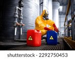 Small photo of Chemicals industry for acid production. Factory worker in hazmat protective suit and gas mask carefully working with hazardous materials.