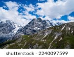 Passing clouds over idyllic landscape in the Alps with snow-capped mountain tops in the background. Alpine mountains ridge landscape in the beauty of the French, Italian and Swiss Alps.
