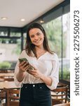 Small photo of Vertical portrait of Happy Hispanic woman using smartphone app in a virtual remote mobile chat meeting, recording stories for social media at home. Business woman concept