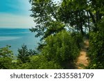 On a Summer day, the view of Lake Michigan from along a dirt hiking trail on a forested bluff near Milwaukee, WI.