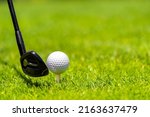 Small photo of Golf ball and golf club on green grass on golf course