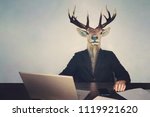 Small photo of head deer's head. The concept of brainlessness and stupidity authorities or government. boss is a fool. stupid entrepreneur sitting at a table with a laptop phone and documents, unwise, thoughtless