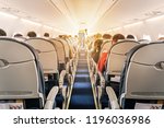 Commercial aircraft cabin with rows of seats down the aisle. morning light in the salon of the airliner. economy class