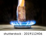 Russian ruble is burning in the fire. concept the rise in the price of gas in Russia. a bill of 5000 rubles burns in a fire on a gas stove. Expensive gas supply