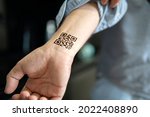 The man shows his hand with a qr code, a confirmation of the vaccination against the covid 19 coronavirus. Temporary tattoo on wrist, Carpus