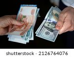 Hands holding russian rouble and us dollar bills. dollars and rubles. concept of currency exchange.