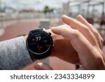 Close-up of smart watch health tracker with the heart rate shown on the screen. Modern stylish and innovation wearable device. athlete checks his heart rate before training at the stadium. heart beat