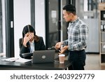 Small photo of Furious two Asian businesspeople arguing strongly after making a mistake at work in modern office
