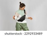 Woman Wearing Crossbody a Black Leather Belt Bag over Grey Background. Handmade Leather Accessories Goods