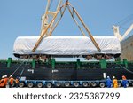 Small photo of Unloading operation of project cargo with port heavy lift cranes A crane on a large cargo ship docks loading a new diesel-electric locomotive. at Laem Chabang Port