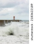 Small photo of Waves crashing against the harbour wall in Porto, Portugal, Europe. Lighthouse in view, space for text, showing strength, natural power and ferocity of the sea 17 MAY 2022