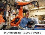 factory worker or engineer operating remote switch controller to control robot machine in the factory