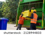 Small photo of Garbage collector, Two garbage men working together on emptying dustbins for trash removal with truck loading waste and trash bin.