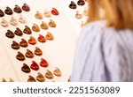 Small photo of Hairdresser salon Woman chooses, looks at hair color samples on palette swatch book in stylist office or home. Beautician,dyeing,changing hair colour,natural,non-toxic,safe haircare concept Horizontal