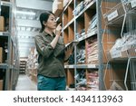 Small photo of wholesale logistic people and export concept. female supervisor with mobile pad at warehouse doing stock taking. elegant young girl storehouse staff counting by digital tablet in stockroom indoors.