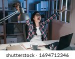 Small photo of Young happy asian japanese woman stay up late in dark house do overtime work on homework. cheerful college girl laughing and screaming after finish project. student celebrating raising arms in air.