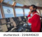 Small photo of defocus and blurred image of a long-haired male sailor wearing a red coverall was piloting the ship, maneuvering the ship to dock. a seafarer under controlling vessel due to maneuver for alongside