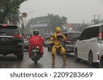 Small photo of jakarta,indonesia-october 2022:a busker is following an iron man costume in the middle of the road