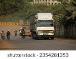 Small photo of jakarta,indonesia-august 28, 2023:traffic on the uphill road, trucks are on the way uphill with a convoy of smaller vehicles and motorbikes