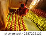 Small photo of KOLKATA, WEST BENGAL, INDIA - 4th November2023: An Woman seen coloring Diya during Diwali. Diwali marks the triumph of the Good over the evil and the biggest and the brightest of all Hindu festival.