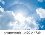 Small photo of Solar corona with cloud in the blue sky. Rainbow halo around the sun with cloud in the blue sky.