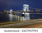 Night view of the iconic Chain Bridge in Budapest, lights tracing its suspension cables and arches