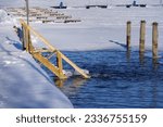 Winter swimming, wooden stairs leading to water in Vaaksy, Asikkala, Finland.