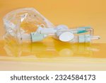 Small photo of Closed suction system for intubated, ventilated neonates and pediatric patients with protective sleeve to isolate pathogens inside and minimize ventilator associated pneumonia on yellow background