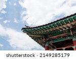 Under the blue sky, the eaves of a traditional building in Korea.
