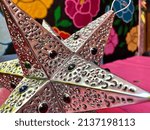 Small photo of Mexican Tin Star on Pink Picnic Table with Floral Background - San Miguel de Allende Mexico - Artisan Crafts