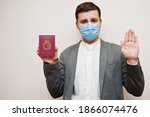 European man in formal wear and face mask, show Malta passport with stop sign hand. Coronavirus lockdown in Europe country concept. 