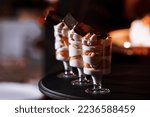 Small photo of cream desserts with berries on candy bar. table with sweets and goodies for the wedding or birthday party reception, decoration dessert table. Delicious sweets on candy buffet. selective focus.